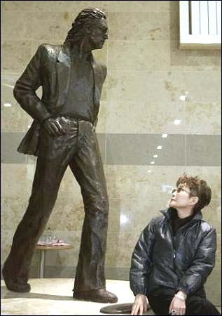 Yoko Ono looks at the Lennon statue at The John Lennon Airport in Liverpool.