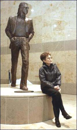 Yoko Ono poses in front of the John Lennon statue at the John Lennon Liverpool Airport.