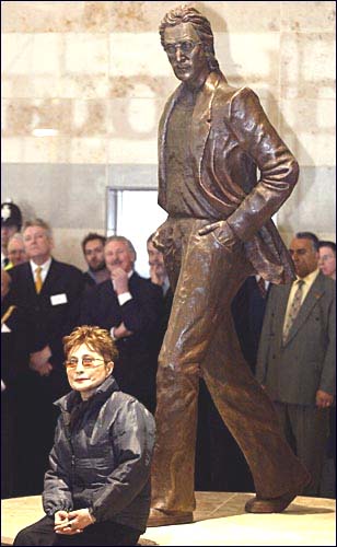 The John Lennon statue dwarfs the diminuative Yoko Ono at the unveiling event at John Lennon Liverpool Airport.