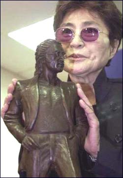 Yoko Ono displays a miniature version of the John Lennon statue at the John Lennon Liverpool Airport.